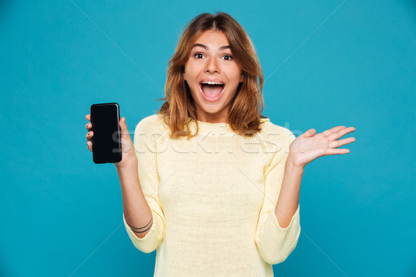 Schreeuwen gelukkig vrouw trui tonen smartphone Stockfoto © deandrobot