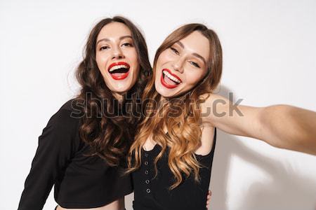Close up picture of two cheerful girls posing together Stock photo © deandrobot
