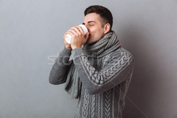 Picture of Sick Man in sweater and scarf drinking tea Stock photo © deandrobot