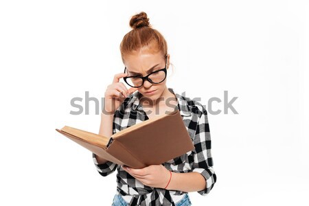 Serious ginger woman in shirt and eyeglasses holding book Stock photo © deandrobot