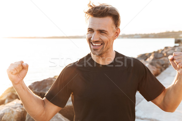 Portrait of a cheerful sportsman Stock photo © deandrobot