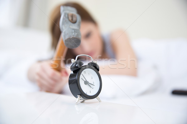 Woman not wanting to get up, taking a hammer to her alarm clock. Focus on clock Stock photo © deandrobot