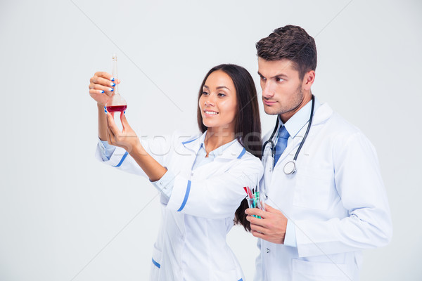 Two medical workers looking at tube with liquid  Stock photo © deandrobot