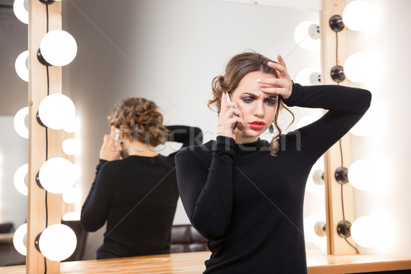 Sad woman talking on the phone Stock photo © deandrobot