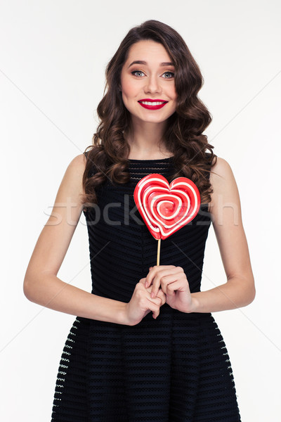 Beautiful happy curly retro styled woman holding heart shaped lollipop Stock photo © deandrobot