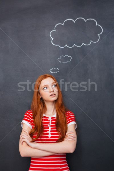 Thoughtful woman thinking over blackboard background with empty speech bubble Stock photo © deandrobot