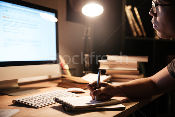 Man sitting and studying with computer at home in nighttime Stock photo © deandrobot