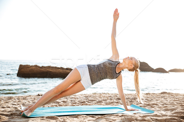 Portrait of a happy woman doing yoga exercises on mat Stock photo © deandrobot