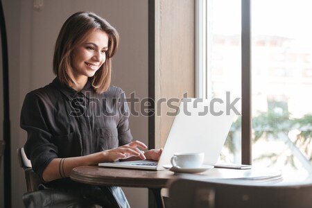 Gorgeous lady sitting at table in cafe talking by phone. Stock photo © deandrobot