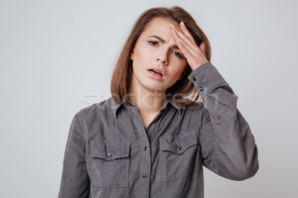 Sick young woman with headache touching her head. Stock photo © deandrobot
