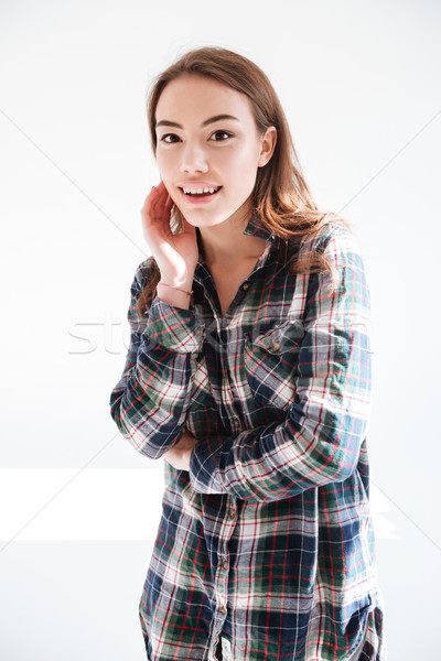 Cheerful lovely yung woman in plaid shirt standing and smiling Stock photo © deandrobot