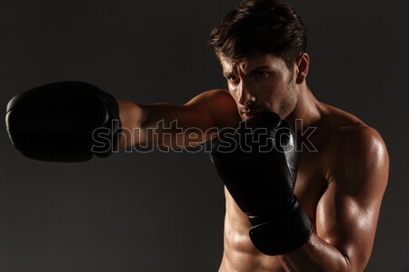 Young african sportsman sitting over black background Stock photo © deandrobot