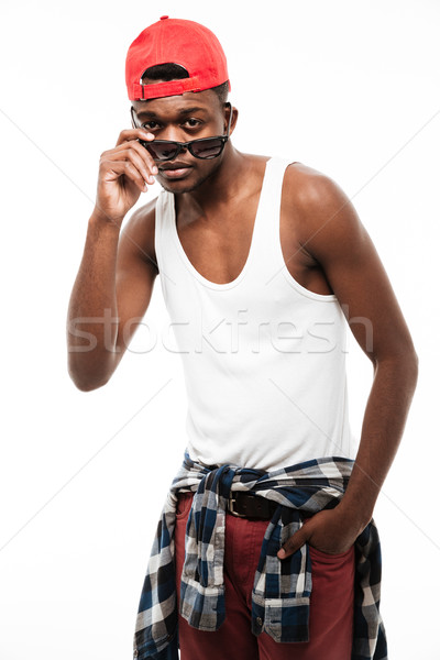 Portrait of handsome african young man in cap and sunglasses Stock photo © deandrobot