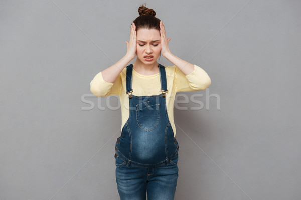 Mujer embarazada dolor de cabeza Foto posando aislado gris Foto stock © deandrobot