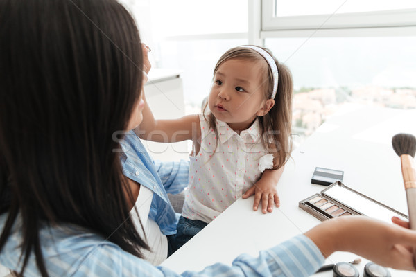 Girl applying make up on her smiling mothers face Stock photo © deandrobot