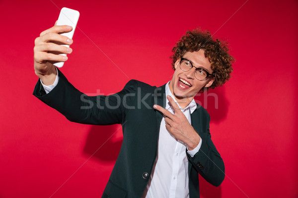Happy man in eyewear taking selfie and showing peace gesture Stock photo © deandrobot