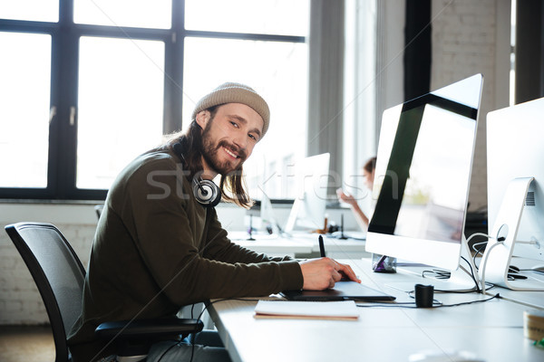 Felice uomo lavoro ufficio guardando Foto d'archivio © deandrobot