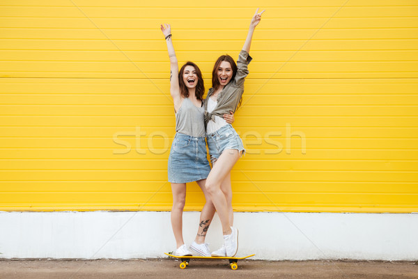 [[stock_photo]]: Heureux · femmes · amis · permanent · jaune · mur