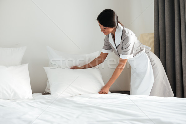 Tineri hotel servitoare in sus pernă pat Imagine de stoc © deandrobot
