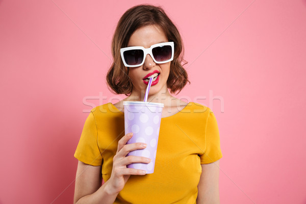 Portrait of a girl in sunglasses holding cup with drink Stock photo © deandrobot