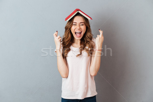 Portrait of a cheerful happy girl holding book Stock photo © deandrobot