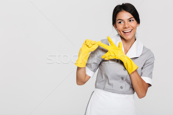 Pretty brunette woman in gray uniform taking off her yellow prot Stock photo © deandrobot