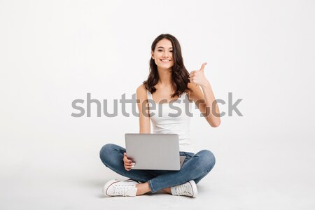 Portrait of a happy girl dressed in tank-top holding laptop Stock photo © deandrobot