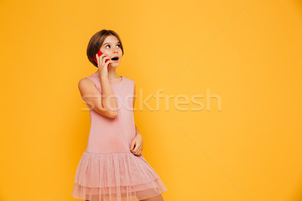 Thoughtful girl looking up at copy space and talking on smartphone isolated Stock photo © deandrobot