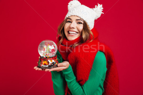 Young pretty lady wearing hat and scarf holding christmas toy Stock photo © deandrobot
