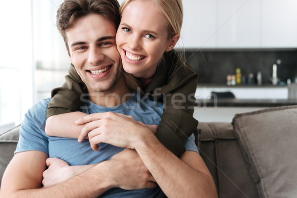 Portrait of beautiful couple sitting in living room Stock photo © deandrobot