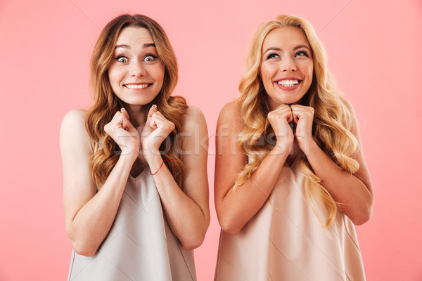 Two surprised happy pretty women in pajamas looking intrigued Stock photo © deandrobot