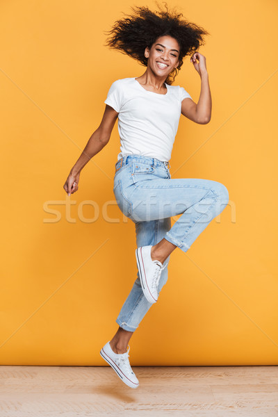 Full length portrait of a cheerful young african woman Stock photo © deandrobot