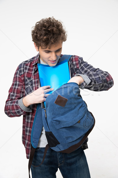 Male student pulls out of a backpack something over gray background Stock photo © deandrobot