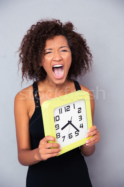 Woman holding clock and shouting  Stock photo © deandrobot