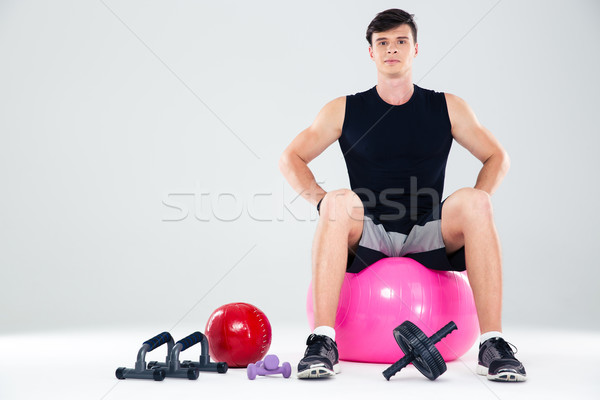 Portrait of a fitness man sitting on the ball  Stock photo © deandrobot
