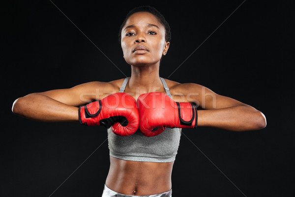 Femeie de fitness prezinta manusi de box negru frumos sportiv Imagine de stoc © deandrobot