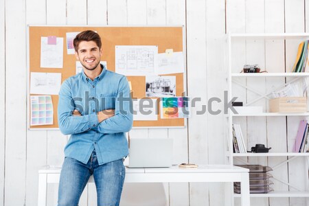 Cheerful man standing at the task board and holding laptop Stock photo © deandrobot