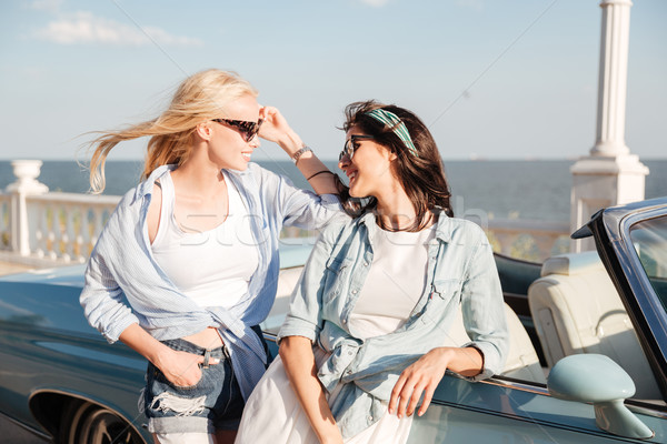 Two happy women standing and talking near cabriolet Stock photo © deandrobot