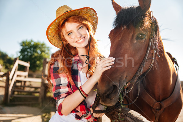 Happy redhead young woman cowgirl in hat with her horse Stock photo © deandrobot