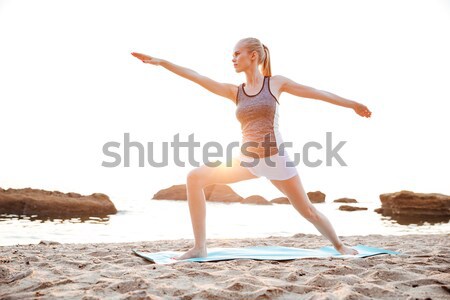 Koncentrált fiatal nő áll jóga póz kint portré Stock fotó © deandrobot