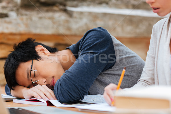 Asian man in glasses sleeping on the lesson Stock photo © deandrobot