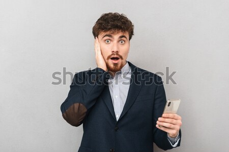 Portrait of a man holding condom and looking at camera Stock photo © deandrobot
