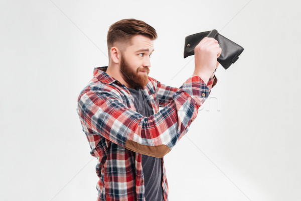 Young man in plaid shirt looking inside his empty wallet Stock photo © deandrobot