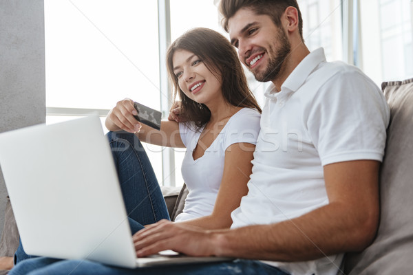Couple sitting and doing online shopping at home Stock photo © deandrobot
