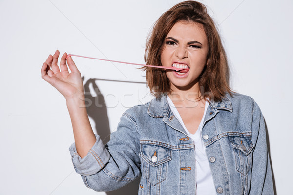 Lady isolated over white background stretching bubble gum Stock photo © deandrobot