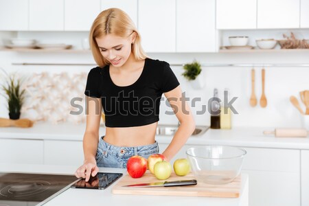 Woman with apple using tablet computer Stock photo © deandrobot