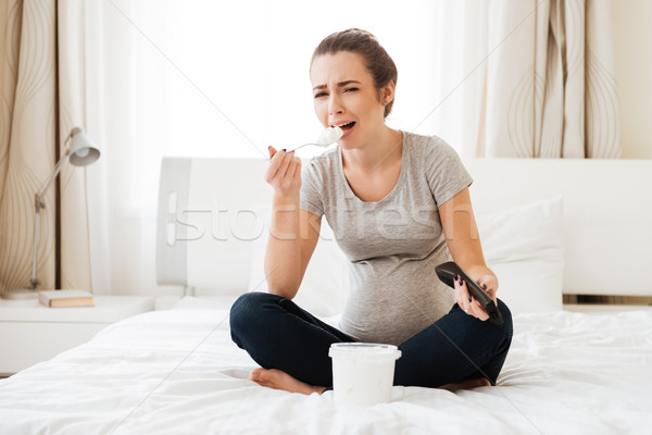 Sad diappointed pregnant young woman eating ice cream and crying Stock photo © deandrobot
