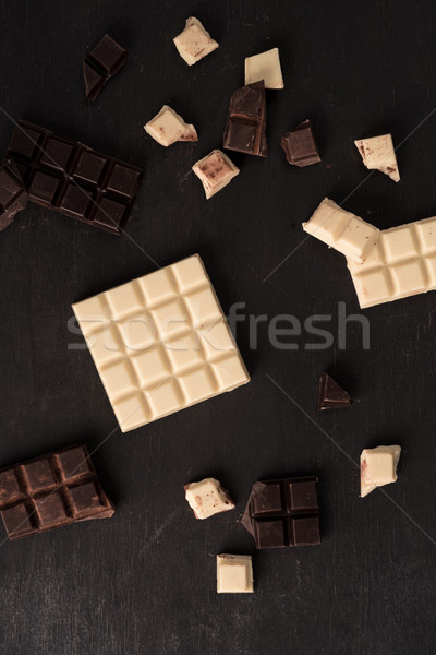 Top view of white and dark crashed chocolate bar tiles Stock photo © deandrobot