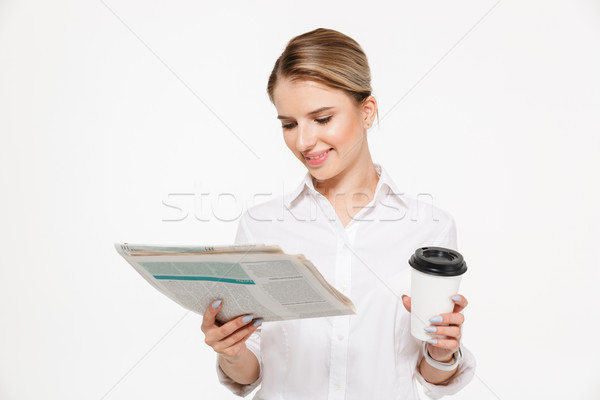 Stock photo: Cheerful blonde business woman reading newspaper