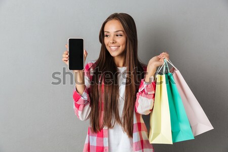Fiatal boldog hölgy tart bevásárlótáskák okostelefon Stock fotó © deandrobot